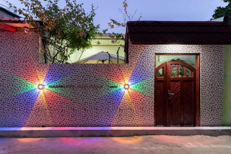 Front of Maafolhey Han'dhaan at night with warm exterior lighting.