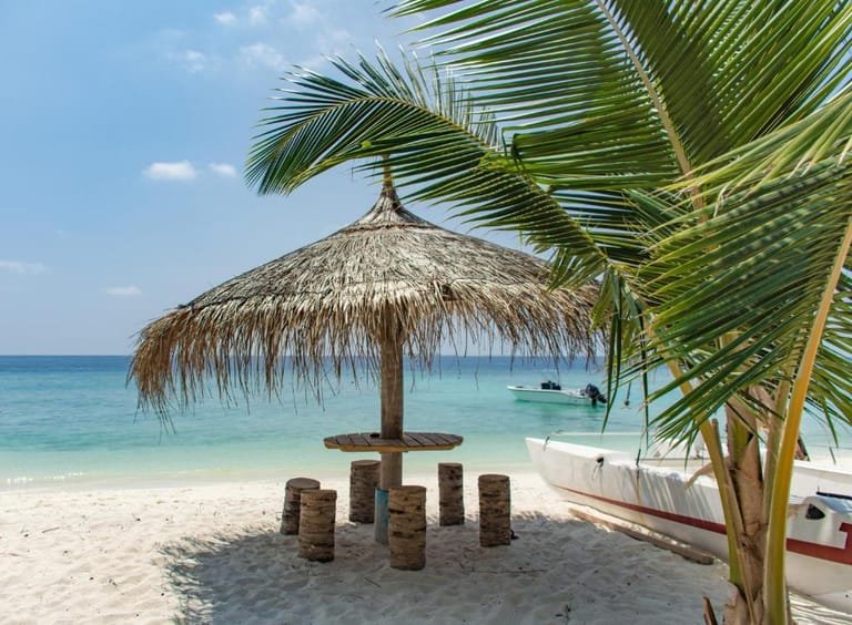 Main beach on Ukulhas with white sand, clear water, and a thatched shelter.