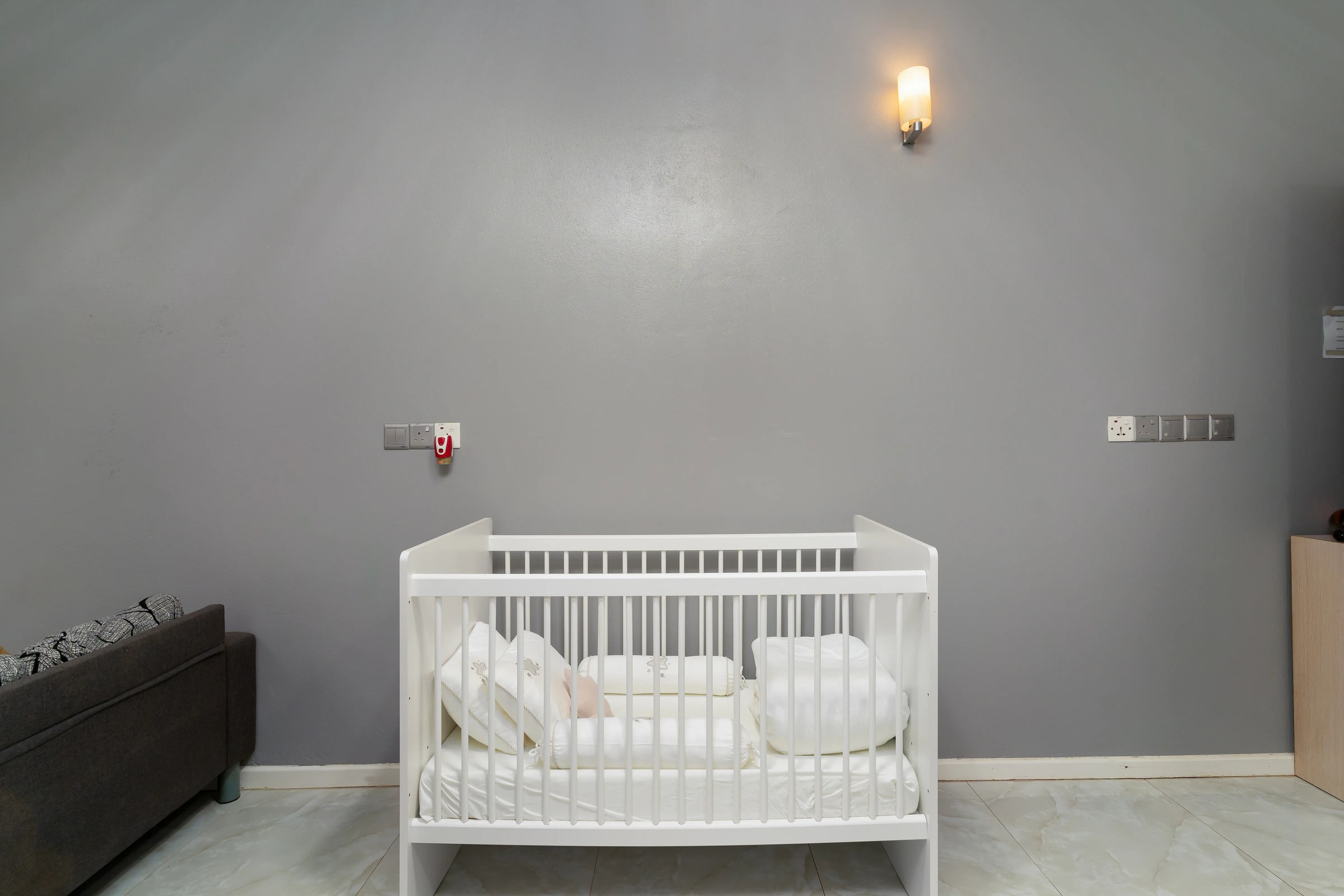A bedroom at Maafolhey set up with a baby cot