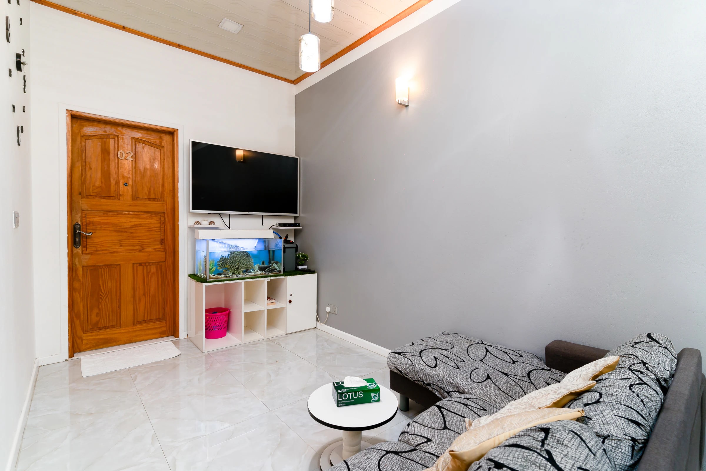 The living room's fish tank beside the sofa and television