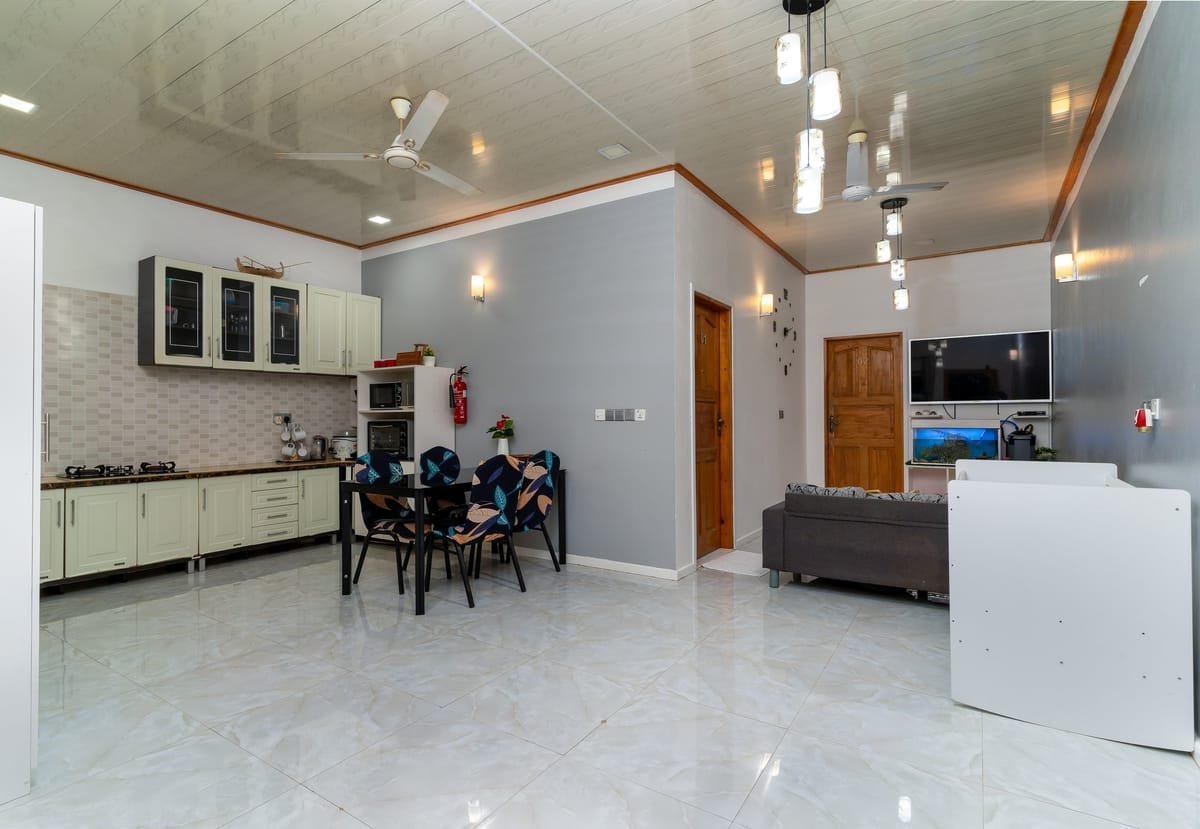 Open-plan interior — kitchen, dining, living all in one warm, light room.